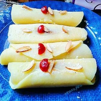 Pati sapta pitha (rice flour crapes filled with cardamom flavoured coconut filling)