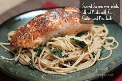 Seared Salmon Over Whole Wheat Pasta with Kale Garlic and Pine Nuts