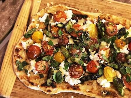 Grilled Pizza With Grilled Tomatoes, Asparagus, Goat Cheese, And Marcona Almonds