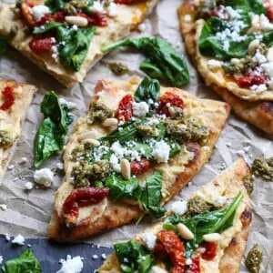 Hummus Flatbread with Sun-Dried Tomatoes, Spinach, And Pesto